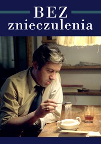 Mężczyzna siedzi przy stole i miesza w filiżance, wygląda na zamyślonego lub zmęczonego. Scena jest ciepło oświetlona przez lampę powyżej. Na górze tekst brzmi „BEZ znieczulenia”. Na stole stoi szklanka napoju i kilka przedmiotów.