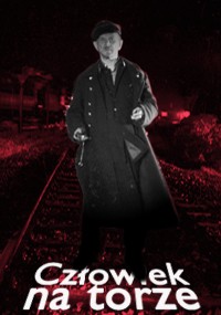 Czarno-biały obraz mężczyzny w długim płaszczu i czapce stojącego nocą na torach kolejowych, z czerwonym blaskiem w tle. Polski tekst na dole brzmi „Człowiek na torze”.