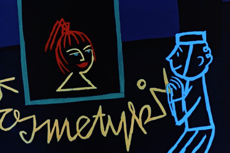 Kolorowa, stylizowana ilustracja przedstawia postać otoczoną niebieskim konturem, wpatrującą się w oprawiony portret rudowłosej kobiety z uśmiechniętą twarzą, umieszczony na ciemnym tle z żółtym, kursywnym tekstem poniżej.