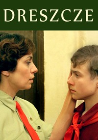 Kobieta w zielonej koszuli i czerwonym krawacie delikatnie trzyma twarz młodego chłopca ubranego w podobny strój. Patrzą na siebie poważnie. Nad nimi na zielonym tle pojawia się słowo DRESZCZE.