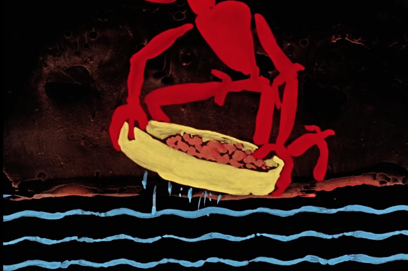 Czerwona abstrakcyjna postać trzyma żółtą miskę wypełnioną brązowymi przedmiotami nad falistymi niebieskimi liniami na ciemnym tle. Styl jest malarski i surrealistyczny, z wyrazistymi, kontrastującymi kolorami.