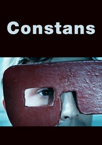 Osoba trzyma dużą, prostokątną czerwoną maskę z otworami na oczy przed twarzą. Powyżej, słowo Constans pojawia się dużymi białymi literami na czarnym tle.