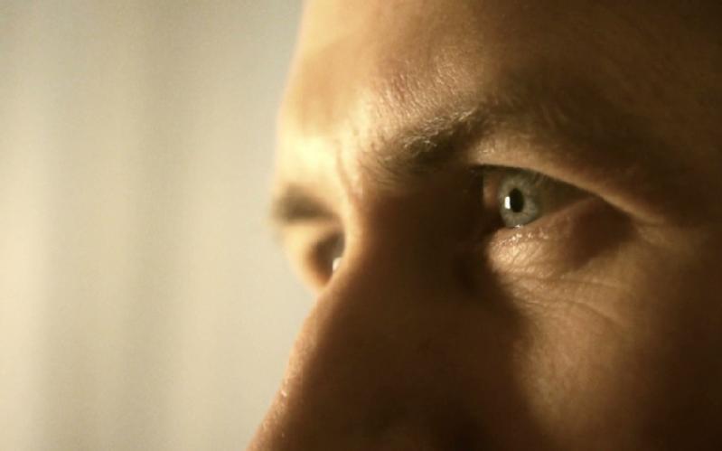 Zbliżenie twarzy osoby skupiającej się na jej niebieskich oczach i zmarszczonym czole, sugerujące głębokie zamyślenie lub koncentrację. Tło jest delikatnie rozmyte.