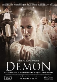 Kobieta w białej sukience stoi z przodu i na środku, wyglądając intensywnie, a grupa ludzi w formalnych strojach siedzi i klaszcze za nią. Polski plakat filmowy pokazuje tytuł Demon i napisy końcowe filmu na dole.