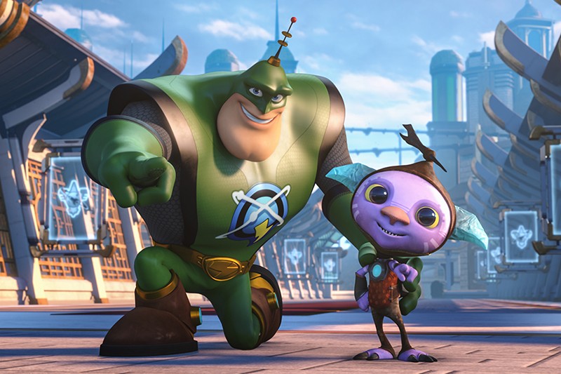 Duży, muskularny superbohater w zielonym kostiumie pewnie pozuje obok małego, fioletowego stworzenia z dużymi uszami i w kamizelce. Stoją na futurystycznej ulicy miasta z eleganckimi budynkami w tle.