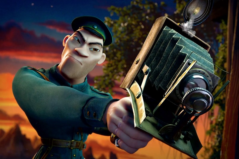 Animowana postać w zielonym mundurze wojskowym agresywnie kieruje staromodną kamerę w stronę widza, na tle dramatycznego zachodu słońca i drzew.