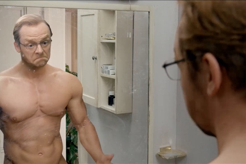Mężczyzna z gołą klatką piersiową i okularami patrzy na siebie w lustrze w łazience ze zdziwionym wyrazem twarzy, jego muskularne ciało odbija się wyraźnie. W tle widać szafkę i półki z przyborami toaletowymi.