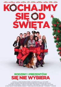 Grupa ludzi w różnym wieku, niektórzy trzymają prezenty, stoją razem owinięte w dużą czerwoną wstążkę. Pies siedzi z przodu. Tło jest białe z polskim tekstem i ozdobionym świątecznym wieńcem na prawej krawędzi.