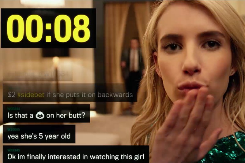 Blondynka przesyła całusa w stronę kamery, a zegar u góry wskazuje 00:08. Na obrazie pojawiają się wiadomości tekstowe i hashtagi, a w tle, w pobliżu drzwi, widać rozmazaną osobę.