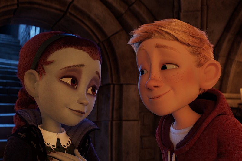 Animowana dziewczynka o zielonkawej skórze i rudych włosach, nosząca opaskę na głowie, uśmiecha się łagodnie do blondwłosego chłopca z piegowatą cerą w czerwonej bluzie z kapturem, gdy stoją razem w kamiennym korytarzu.