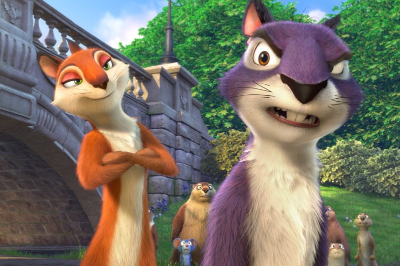 Dwie animowane wiewiórki, jedna pomarańczowa ze złożonymi ramionami i jedna fioletowa ze sceptycznym wyrazem twarzy, stoją przed kamiennym mostem. W tle widać inne zwierzęta i zielone drzewa.