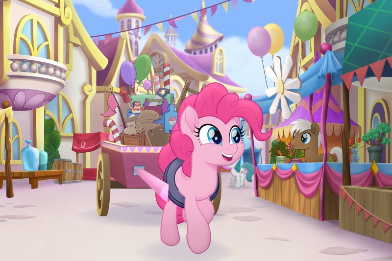 Radosny, różowy kucyk z kreskówek z kręconymi włosami kłusuje przez kolorową, świąteczną ulicę wioski, ozdobioną balonami i flagami. Kucyk ciągnie wózek wypełniony słodyczami w tle, a inny kucyk stoi przy straganie.