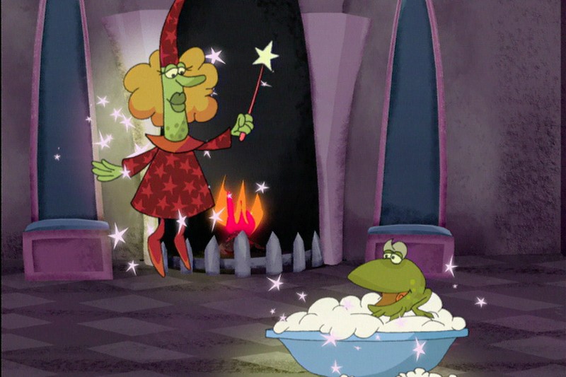 Kreskówkowa wiedźma w sukni w gwiazdki unosi się z różdżką, rzucając iskry na zieloną żabę biorącą kąpiel z pianą w niebieskiej wannie. W tle kamiennego pokoju jarzy się kominek.