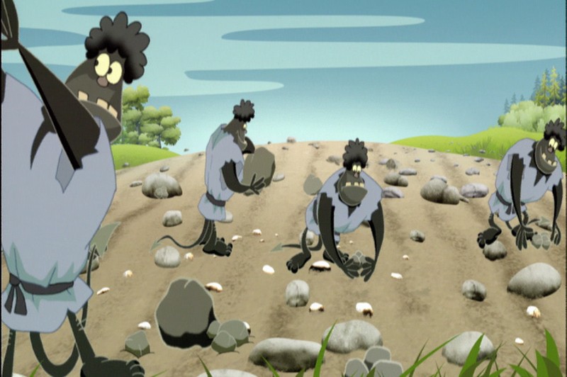 Cztery kreskówkowe małpy o zaniepokojonych minach ubrane są w niebieskie koszulki i zbierają kamienie na ścieżce otoczonej zielenią, pod błękitnym niebem z chmurami.