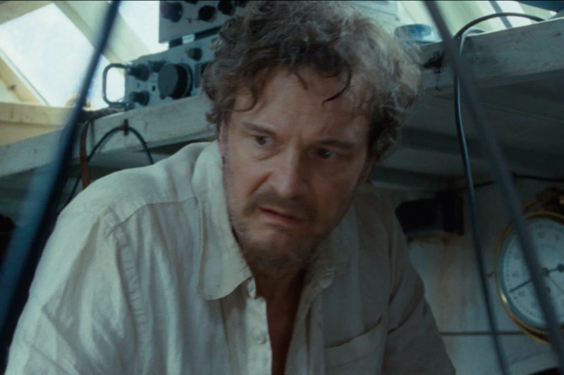 Rozczochrany mężczyzna w pogniecionej białej koszuli wygląda na zmartwionego, kucając w kabinie łodzi wypełnionej sprzętem, w tle widać zegar.