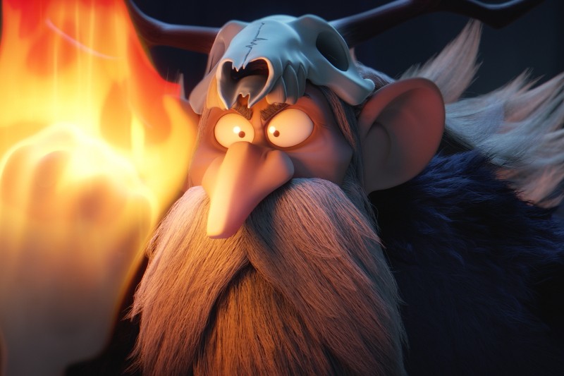 Kreskówkowy czarodziej z długą, białą brodą i hełmem w kształcie czaszki intensywnie wpatruje się w jaskrawe, ogniste światło w swojej uniesionej dłoni, które rzuca dramatyczne światło na jego twarz.