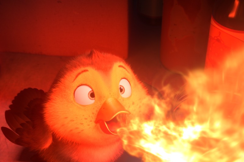 Puszysty, animowany ptak z szeroko otwartymi oczami zieje dużym strumieniem ognia z otwartego dzioba, oświetlonego jasnopomarańczowymi płomieniami w słabo oświetlonym otoczeniu.
