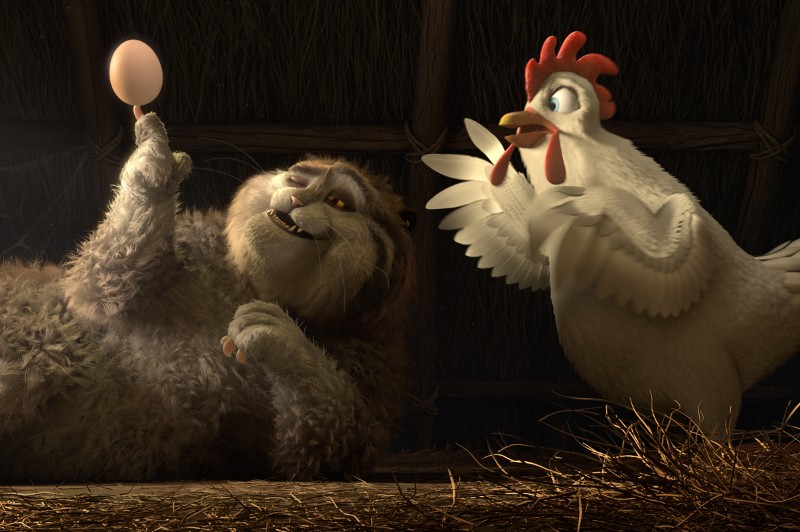 Duży kot szczerzy zęby, leżąc na boku, trzymając jajko jednym palcem. Przestraszony kurczak stoi nieopodal, trzepocząc skrzydłami w przerażeniu, z sianem rozrzuconym na ziemi w słabo oświetlonej stodole.