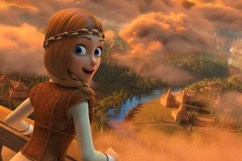 Animowana dziewczynka z długimi, kasztanowymi włosami i ozdobioną klejnotami opaską na głowie uśmiecha się, spoglądając z balkonu na oświetlony słońcem, pokryty chmurami fantastyczny krajobraz z rzekami i małymi budynkami poniżej.