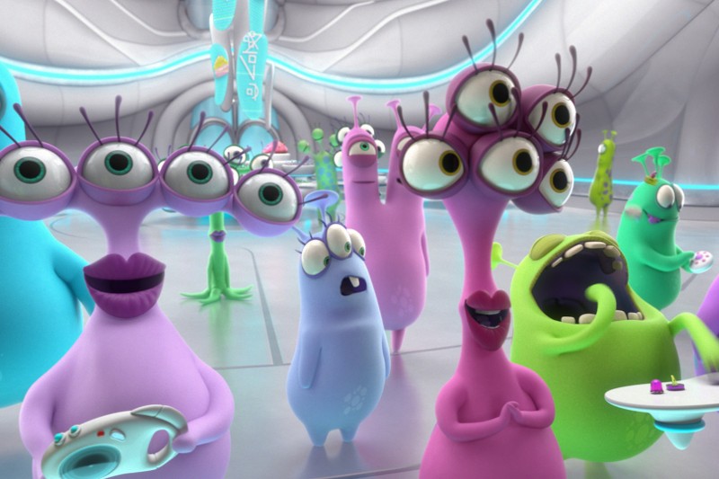 Grupa kolorowych, kreskówkowych kosmitów z wieloma oczami i wyrazistymi twarzami stoi razem w futurystycznym, białym pokoju z błyszczącymi niebieskimi akcentami. Niektórzy kosmici wydają się zaskoczeni, szczęśliwi lub zabawni.