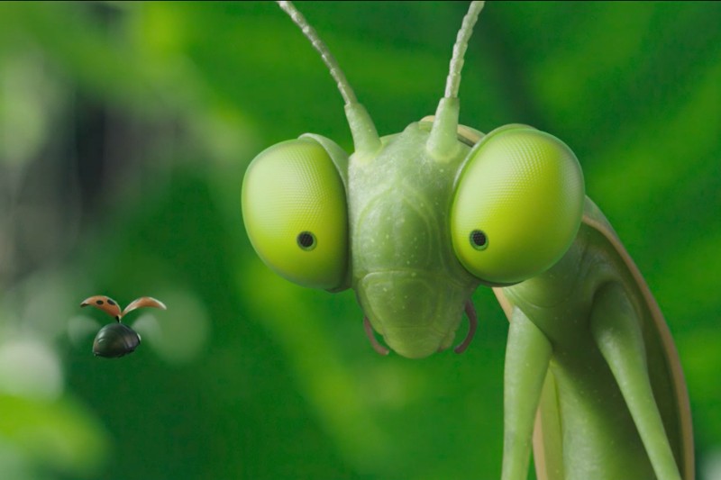 Zbliżenie na zieloną, animowaną modliszkę z dużymi, wyrazistymi oczami wpatrzonymi w małą biedronkę z rozłożonymi skrzydłami, na rozmytym zielonym tle.