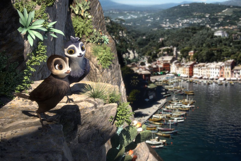 Dwa animowane ptaki stoją na skalistym klifie porośniętym zieloną roślinnością, z widokiem na nadmorskie miasteczko i port pełen łodzi, otoczony bujnymi wzgórzami i błękitną wodą pod słonecznym niebem.