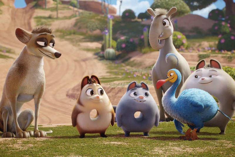 Grupa animowanych zwierząt, w tym wilk, dwa białe koty, niebieski ptak, osioł i dwa okrągłe stwory o dużych oczach, stoją razem na trawie w kolorowym, słonecznym krajobrazie.