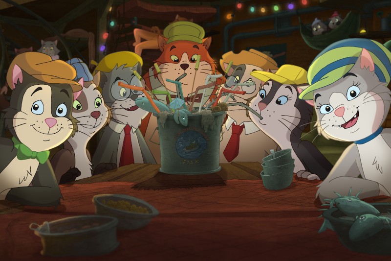 Grupa animowanych kotów w kapeluszach i krawatach siedzi przy stole, podekscytowana wyciągając ości z ryb do metalowego wiadra stojącego pośrodku stołu. W słabo oświetlonym pomieszczeniu panuje świąteczna i psotna atmosfera.