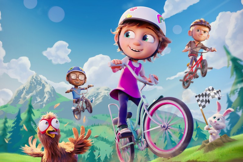 Animowana scena trójki dzieci jeżdżących na rowerach na zewnątrz z górami w tle. Dziewczynka z przodu nosi kask i się uśmiecha, podczas gdy kurczak i królik z szachownicą obserwują z trawy.