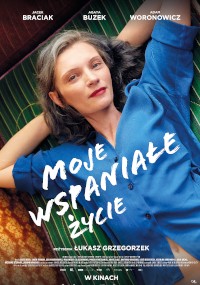 Kobieta o jasnej karnacji i czerwonej szmince leży na zielonej, pasiastej kanapie, ubrana w niebieską koszulę. Polski tytuł filmu Moje Wspaniałe Życie jest napisany białym tekstem na obrazie.