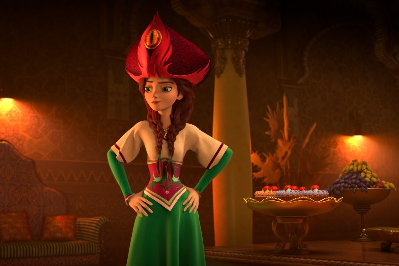 Ożywiona kobieta ubrana w wysoki, ozdobny czerwony kapelusz i zieloną sukienkę stoi z rękami na biodrach w słabo oświetlonym, bogato zdobionym pokoju, a obok niej na stole leżą owoce i ciastka.
