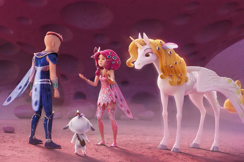 Dziewczynka-wróżka i chłopiec-wróżka ze skrzydłami rozmawiają obok małej kozy i białego jednorożca ze złotą grzywą w różowym, przypominającym jaskinię otoczeniu.