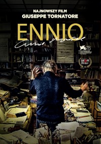 Mężczyzna stoi w zagraconym pokoju wypełnionym książkami i papierami, odwrócony tyłem z uniesionymi rękami. Napis głosi „Najnowszy Film Giuseppe Tornatore ENNIO” z nagrodami i logo festiwali.