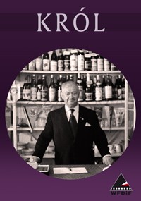 Czarno-białe zdjęcie starszego mężczyzny w garniturze stojącego za barem lub ladą z półkami butelek i szkła za nim. Słowo KRÓL pojawia się powyżej, a małe logo WFDIF znajduje się w prawym dolnym rogu.