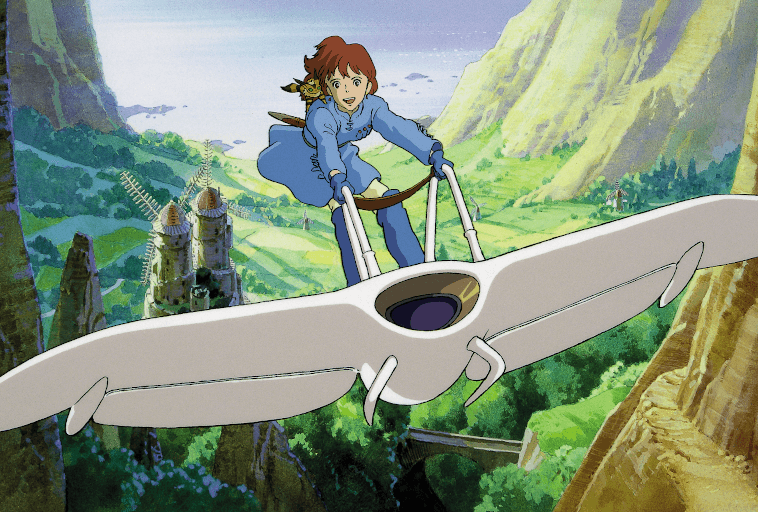 Młoda kobieta o rudych włosach leci szybowcem nad bujną zieloną doliną z górami, wiatrakami i drzewami w tle. Scena jest żywa i animowana w stylu fantasy.