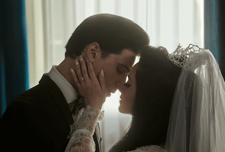 Panna młoda i pan młody w strojach ślubnych dzielą intymną chwilę, dotykając czoła i zamierzając się pocałować. Panna młoda ma na sobie koronkową suknię, welon i tiarę, a pan młody ciemny garnitur. Za nimi świeci delikatne światło.