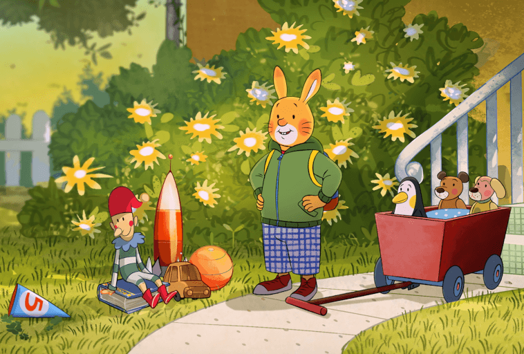 Wesoły królik z kreskówki w zielonej kurtce stoi na ścieżce obok czerwonego wozu wypełnionego pluszakami. W pobliżu znajdują się zabawki, w tym lalka klauna, rakieta, piłka i samochodzik, w słonecznym ogrodzie z kwiatami stokrotek.
